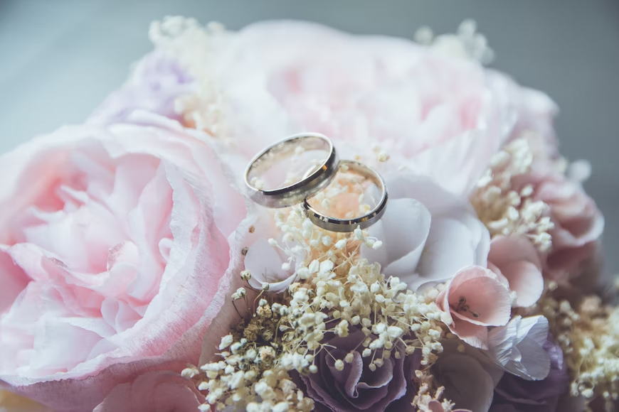 wedding rings on top of the flowers
