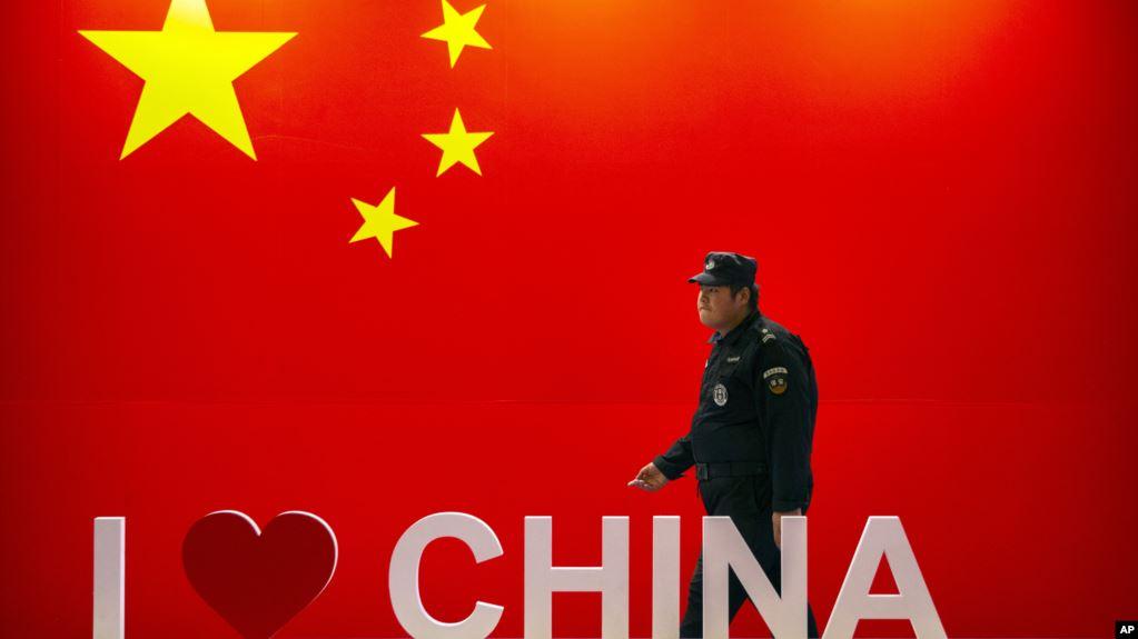 安保人员从中国国旗和“我爱中国”标志旁走过。