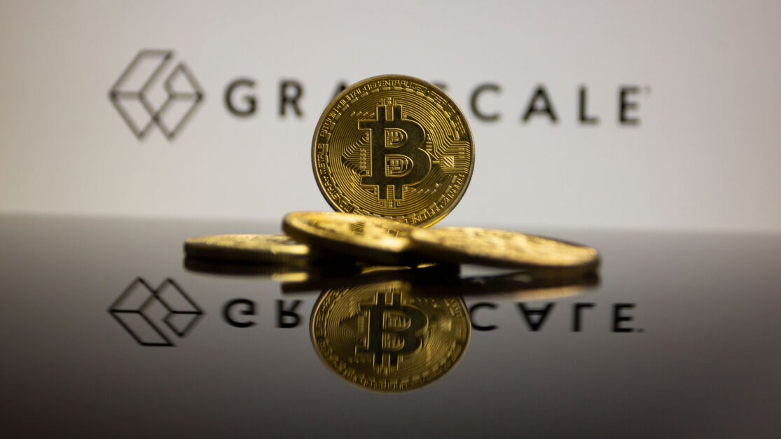 Picture of Bitcoin coin in front of the logo for Grayscale