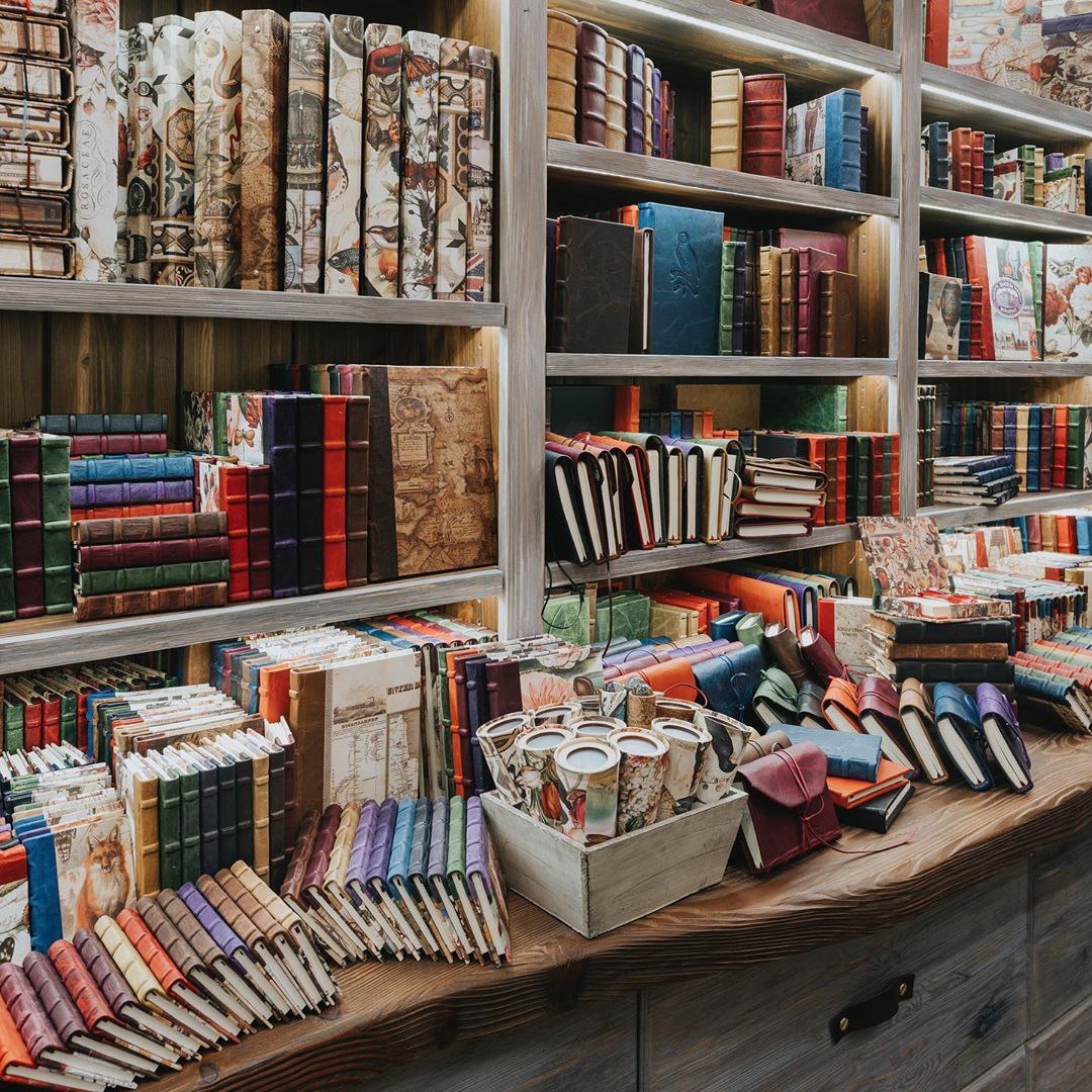 Shelves of leather bound notebooks, with colourful and artistic designs