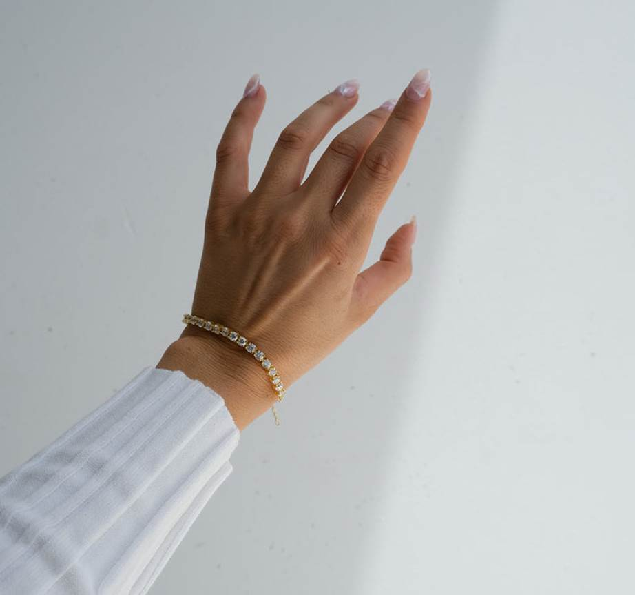 A hand with a bracelet on it

Description automatically generated
