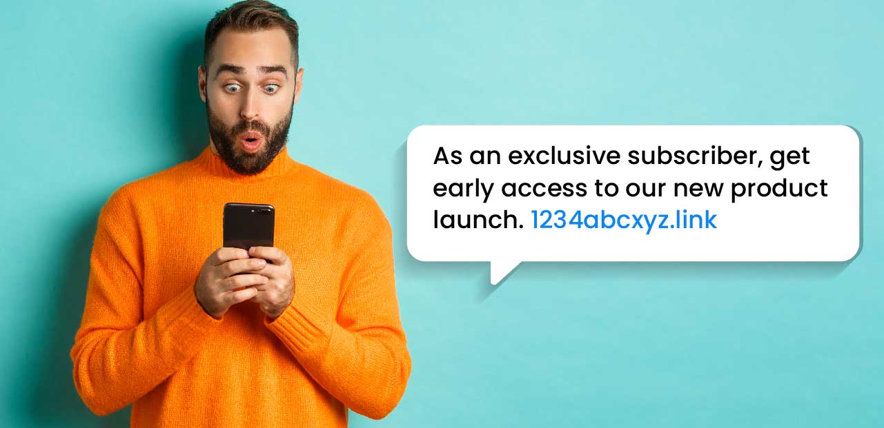 Make your SMS exclusive | A male in an orange turtleneck excitedly reads an exclusive SMS offer on his smartphone, with the SMS message in display.