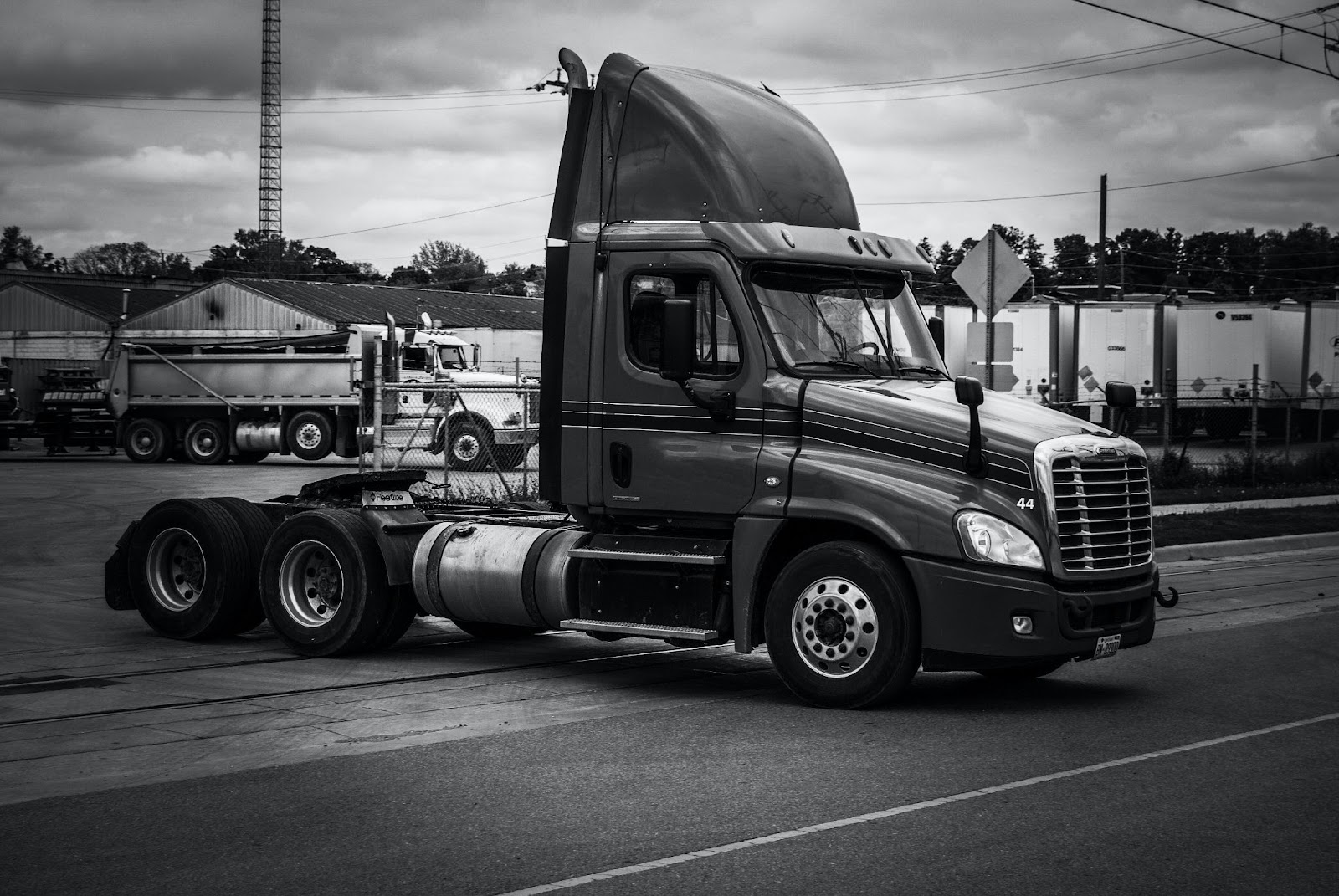 A flatbed truck leaving a truck yard.