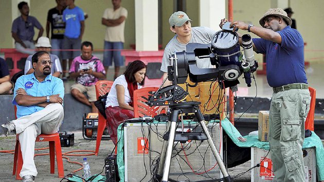 Peneliti dari Badan Penerbangan dan Antariksa Amerika Serikat memeriksa alat sembari menunggu awan  yang masih menutupi Matahari di Maba, Halmahera Timur,  Maluku Utara, Rabu (9/3). Pengamatan dan penelitian proses gerhana matahari total di Maba terganggu  awan yang menutupi Matahari.