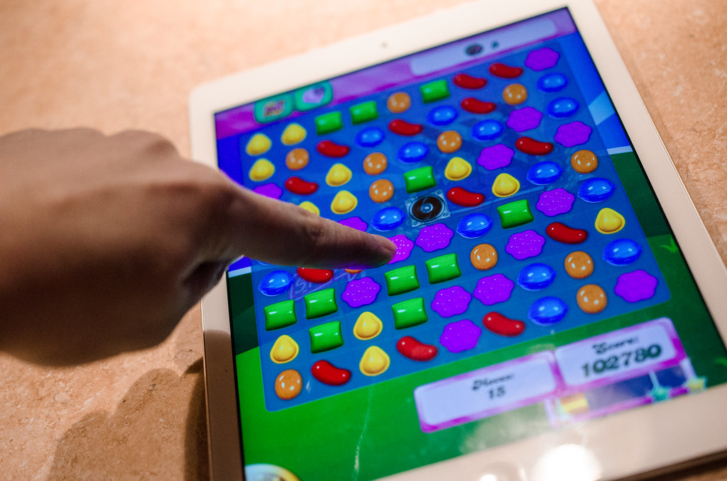 A person playing candy crush on a mobile device. Understanding AI technology.