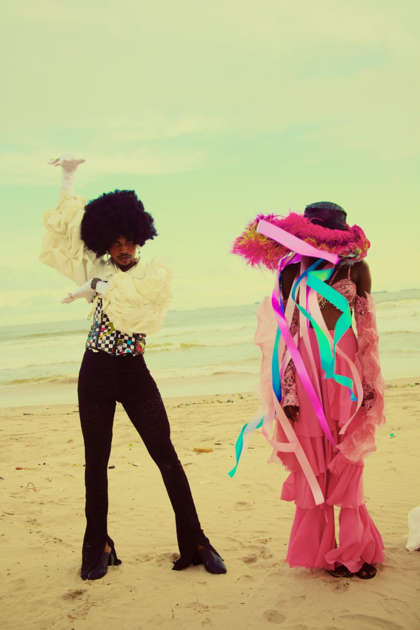 A male model rocking a corset top and afro wig alongside the model with a pink outfit for Pink Noise, a fashion film