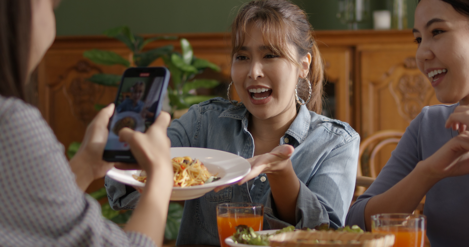 A social media influencer takes a photo of a restaurant dish