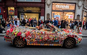 A man drives an elaborately decorated Saab through Oxford Circus, London, UK