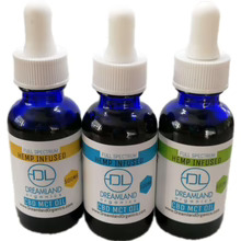 Three bottles of hemp-derived MCT CBD oil by dreamland organics, two unscented and one mint-infused.