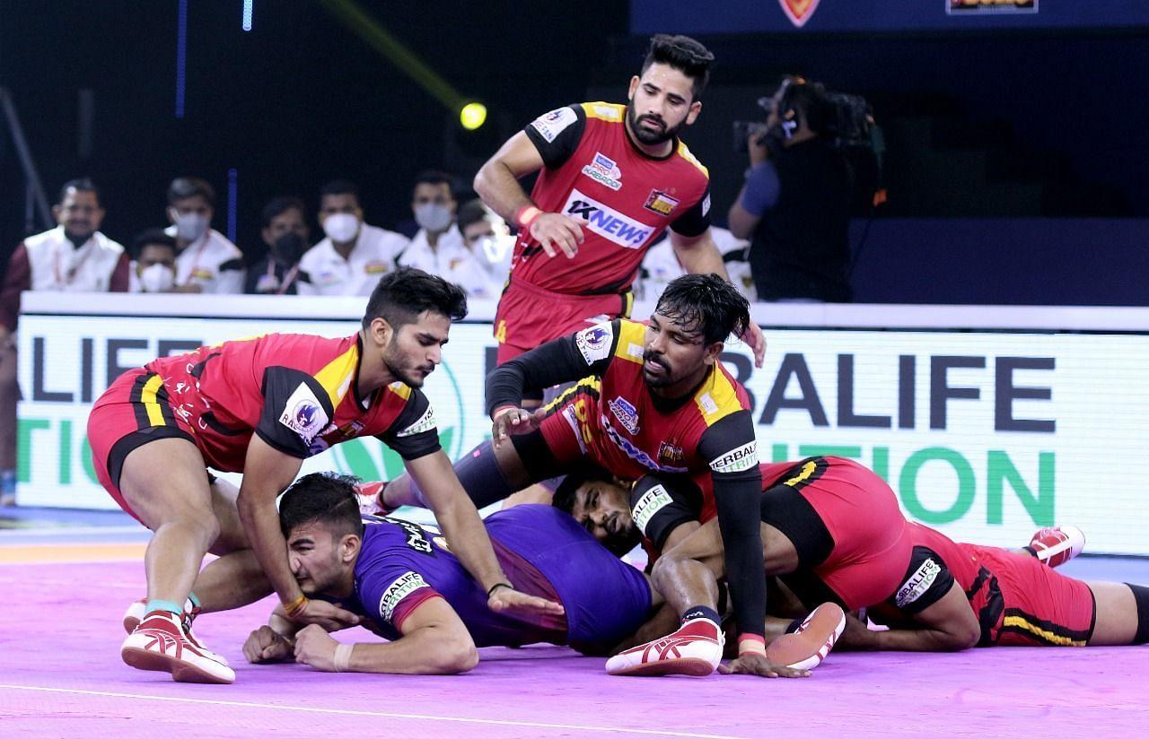 Bengaluru Bulls defenders pile their bodies on the body of a raider