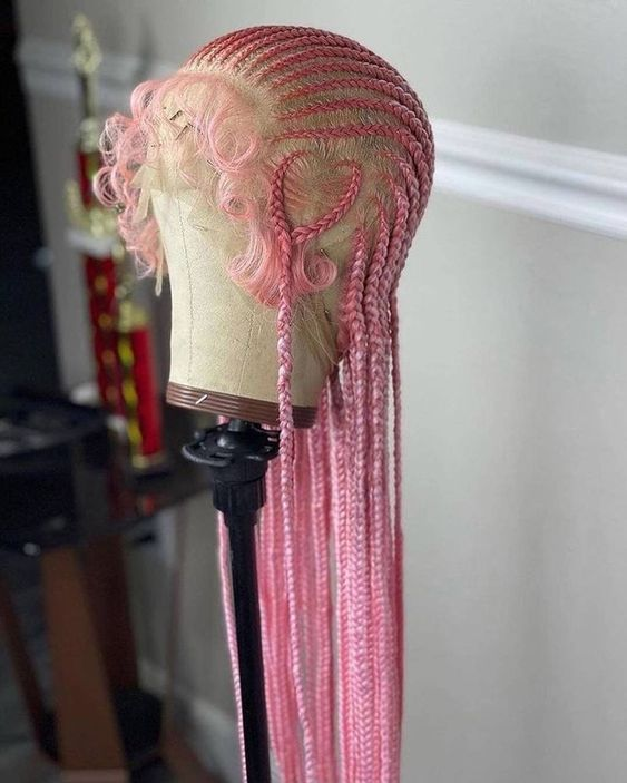 A pink cornrow wig on a wig stand