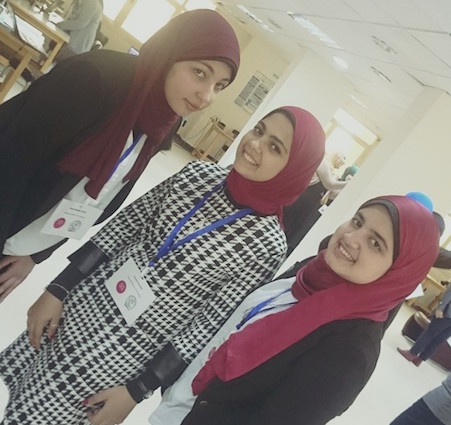 ثلاث فتيات يرتدين حجابًا باللون الأحمر الداكن
