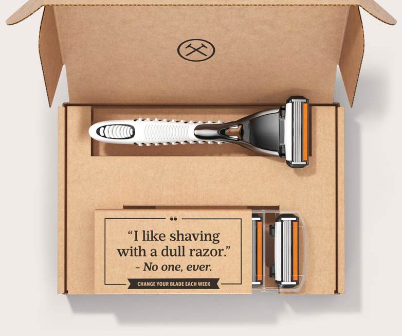 Dollar Shave Club box with "I like shaving with a dull razor - no one, ever" written inside it.