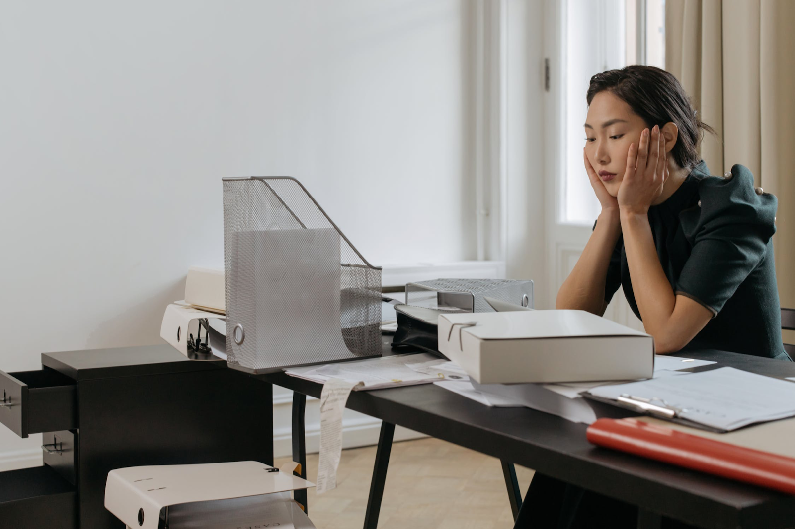 Woman sitting at office desk feeling frustrated.