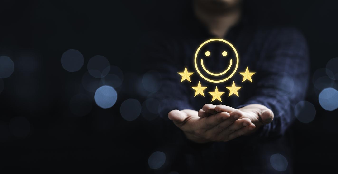 Empresário segurando ícone sorriso para a melhor avaliação, conceito de satisfação do cliente