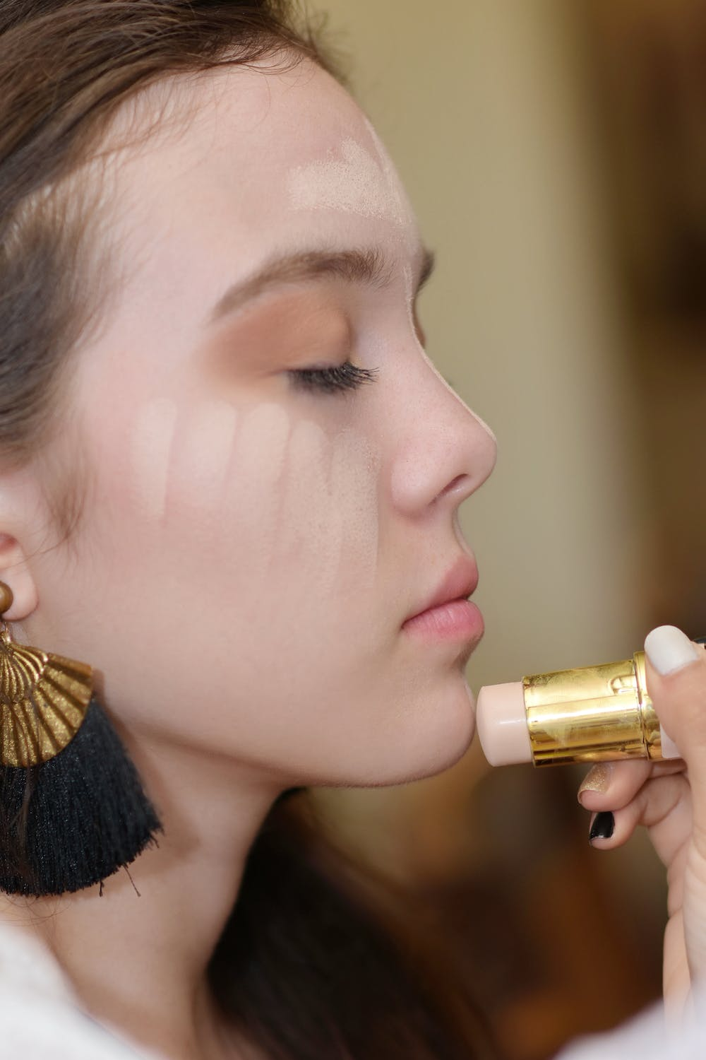 woman applying foundation using a stick foundation