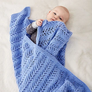baby snuggled in lacy chevron knitted blanket