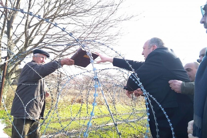 Экс-президент Грузии Гиорги Маргвелашвили общается с Датой Ванишвили. REUTERS / Давид Мдзинаришвили. История про дедушку Дату, который живет за колючей проволокой в селе Хурвалети в Грузии