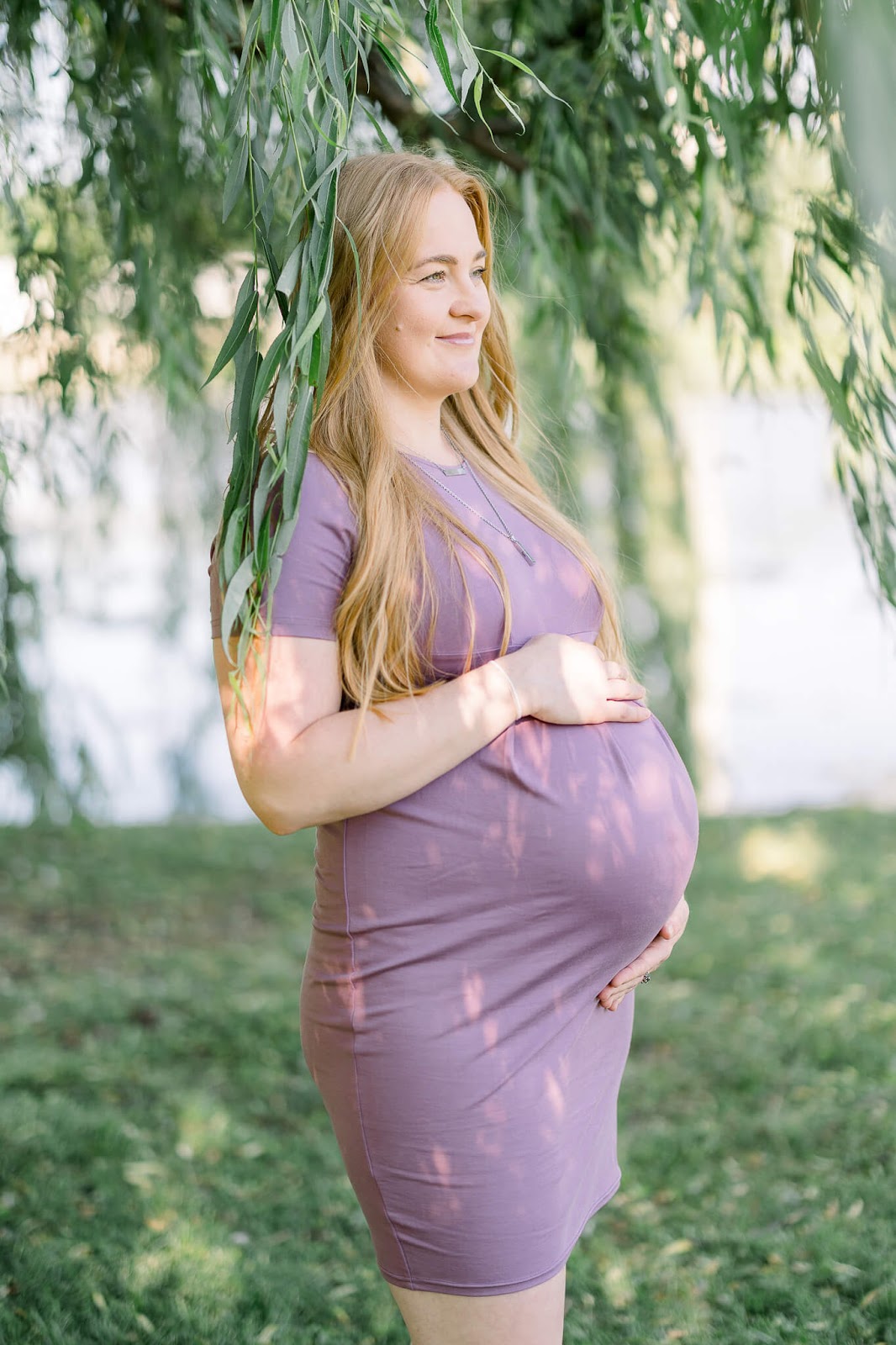 Pregnant woman posing under a tree