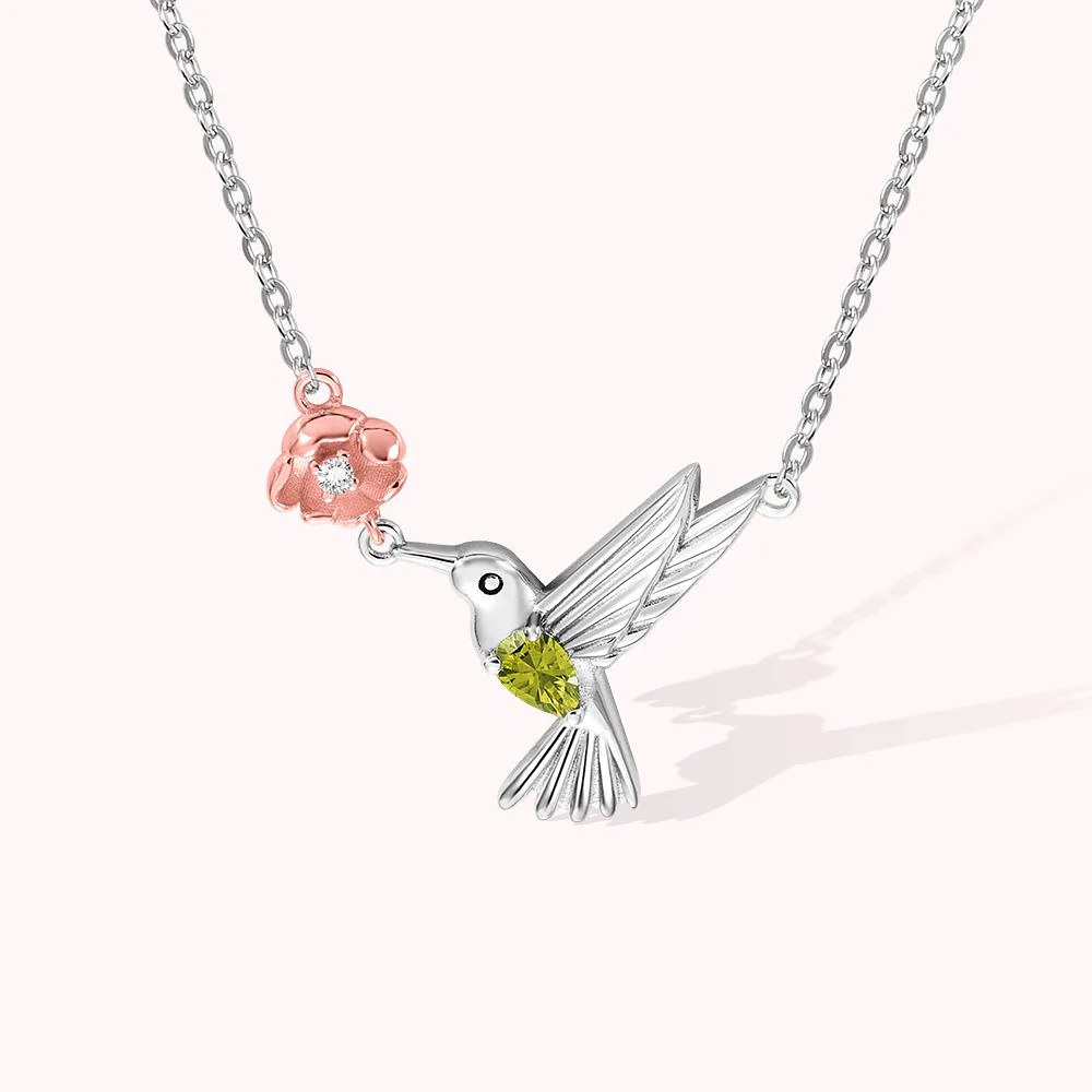 Collier en forme de fleur de naissance rose, butinée par un colibri au ventre vert. 