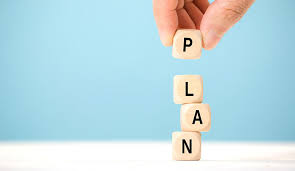 Image: Building blocks spelling out the word 'Plan,' symbolizing the foundational importance of constructing a well-thought-out plan in the process of descriptive writing.