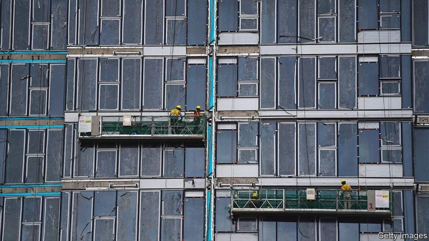 Workers are suspended on the side of an apartment building construction site in Ho Chi Minh City on September 22, 2022. (Photo by Nhac NGUYEN / AFP) (Photo by NHAC NGUYEN/AFP via Getty Images)