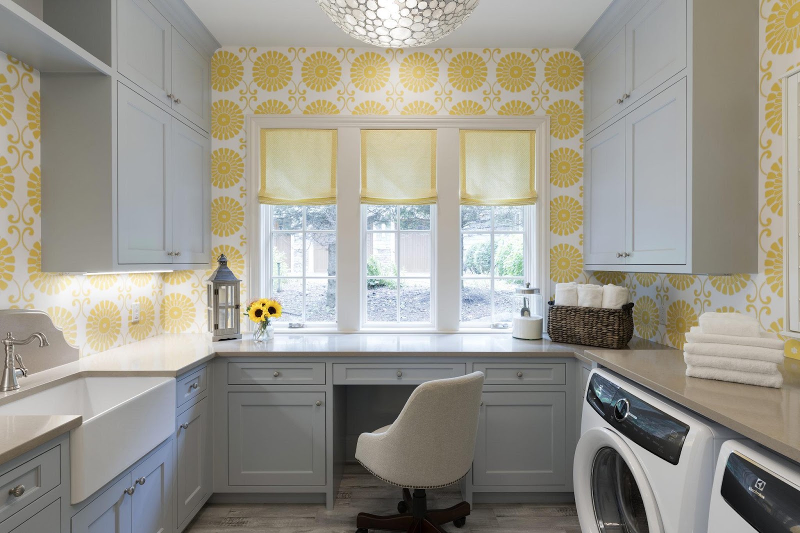 A laundry room with a private office and bright yellow flowers on the walls