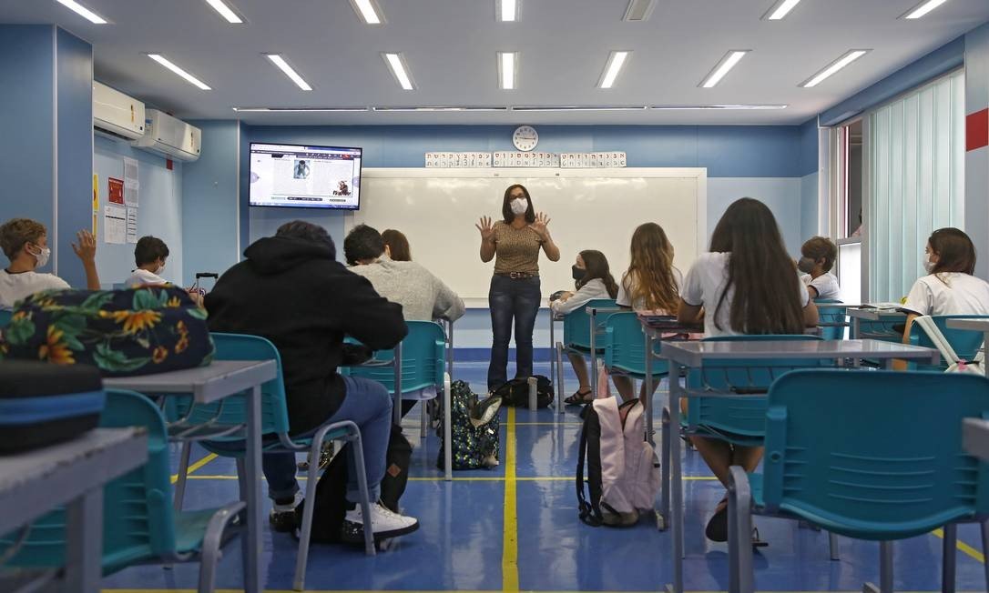 Uma professora leciona no colégio Eliezer Max, no Rio. A maioria dos alunos da escola voltou ao ensino presencial em 2021, mas alguns deles ainda acompanham as lições de casa. Foto: Fabio Rossi / Agência O Globo