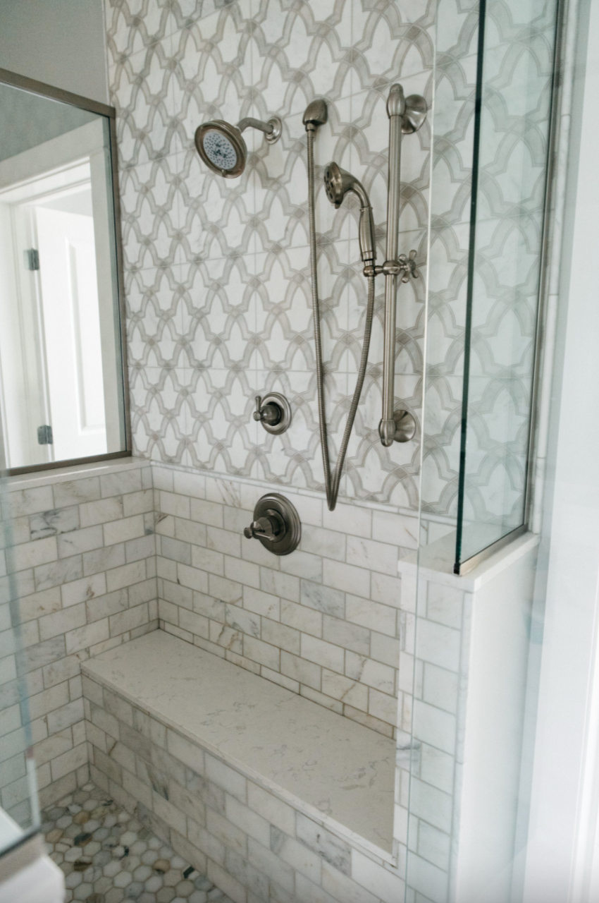 Marble tiled shower with multiple shower heads by East and Gray Interiors | Columbus, Ohio