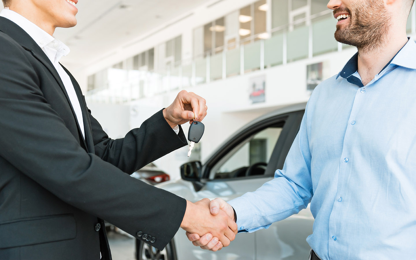 car dealer handing car keys to customer