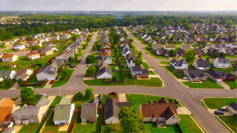 Aerial view of a lovely residential neighborhood in Murfreesboro, Tennessee. Houses are spread out on large lots with lush, green lawns and wide neighborhood streets. 