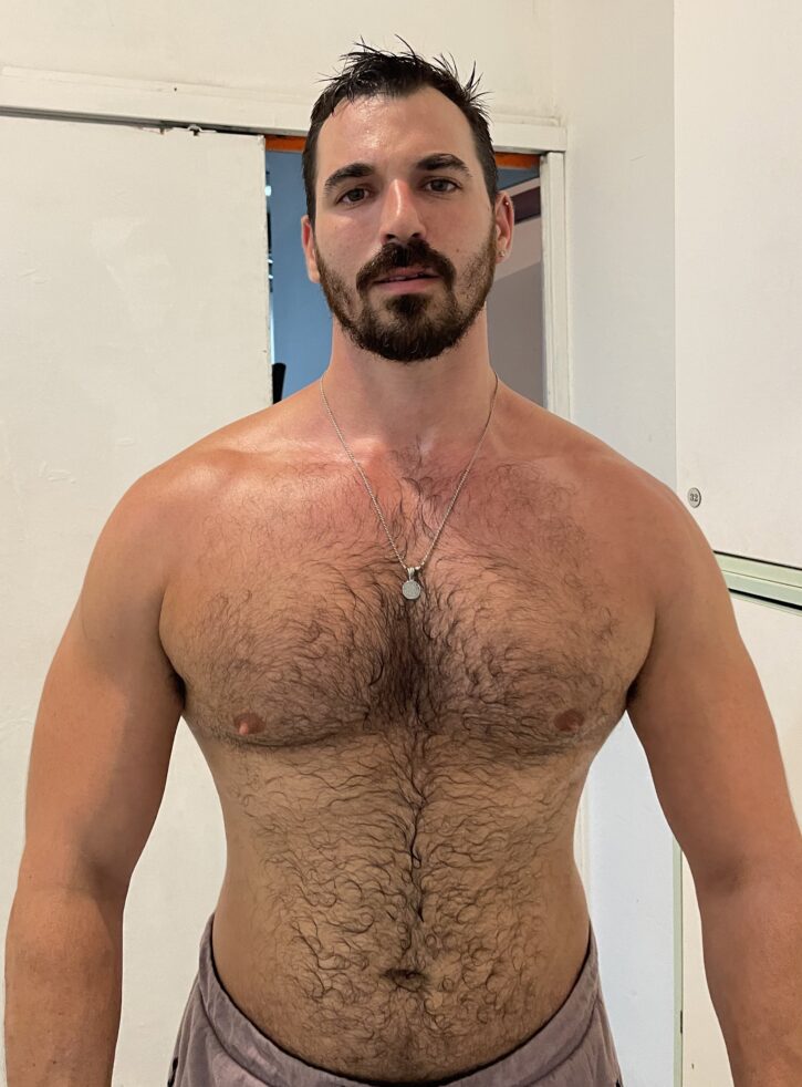 sweaty and shirtless Thick Macho posing for a photo to share to his twitter followers
