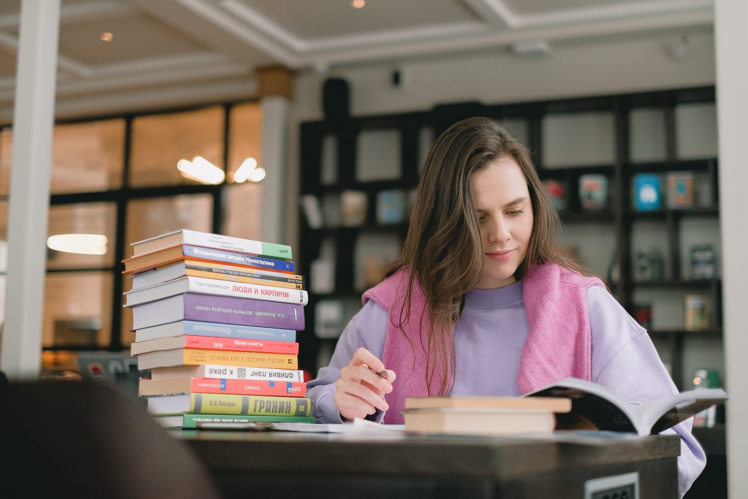 A girl reading books in a library.