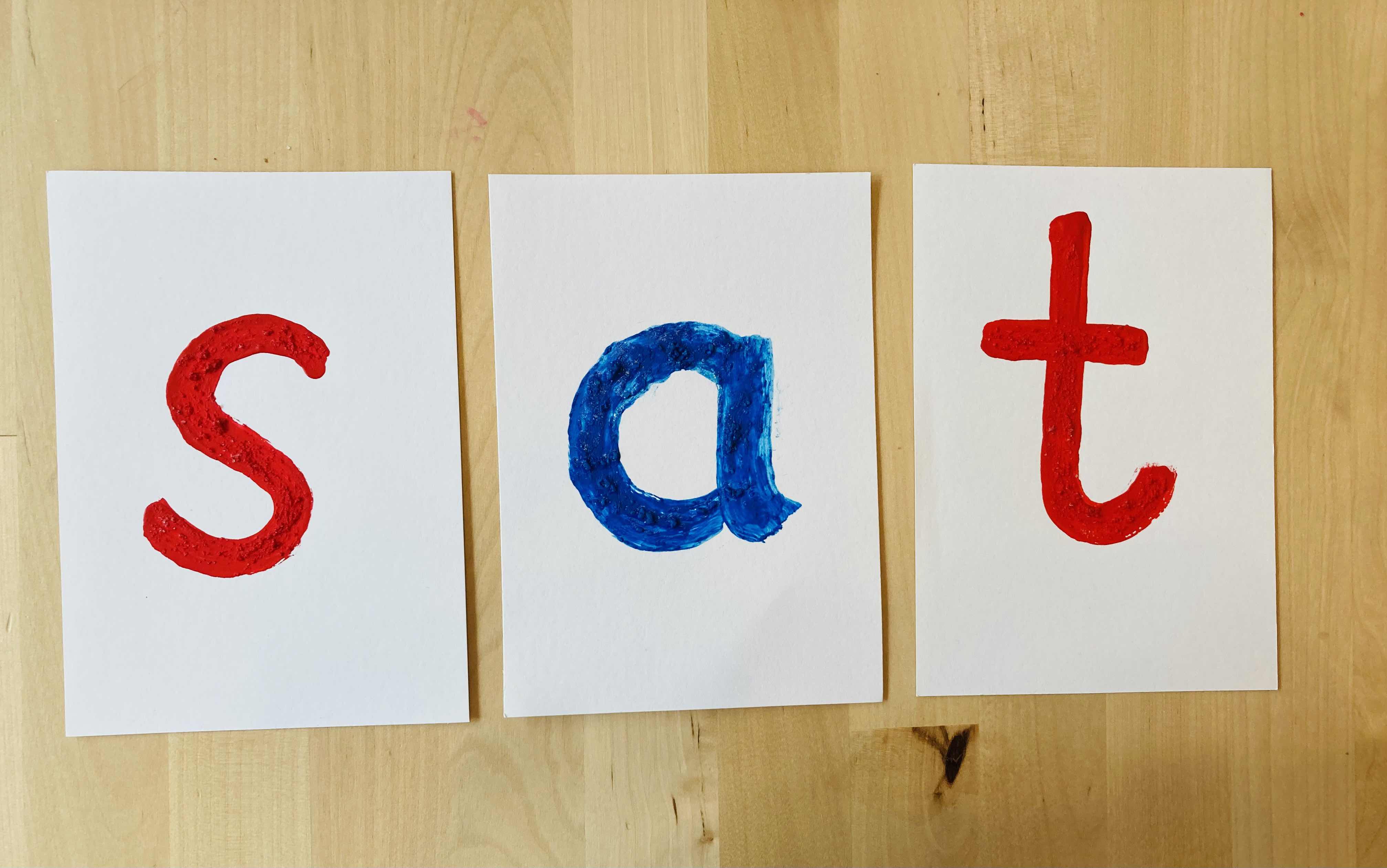 sensory letter cards spelling out the word 'sat'
