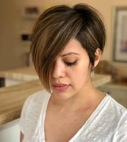 Woman looking down showing her pixie cut with highlights