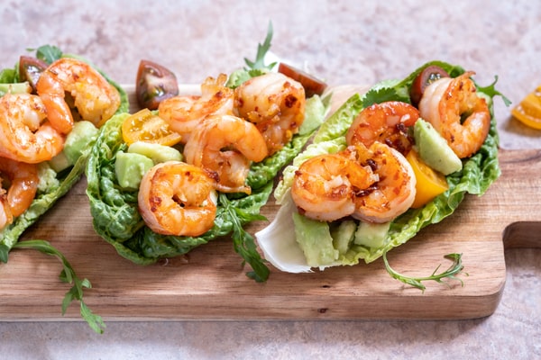 Shrimp tacos in lettuce wrap served on a wooden board