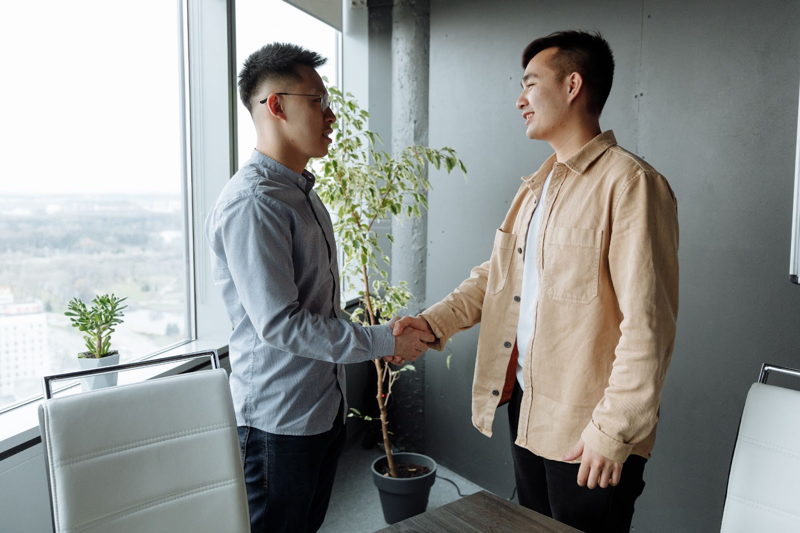 Two Asian men shaking hands at the end of an interview