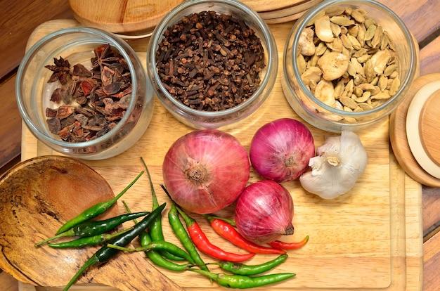 Photo cooking ingredients. spice and herbs with onion and garlic on wooden board