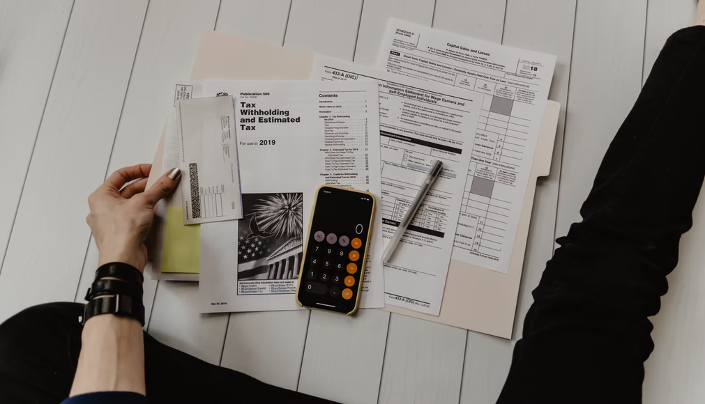 A flatlay of taxes and a calculator referencing budget-keeping