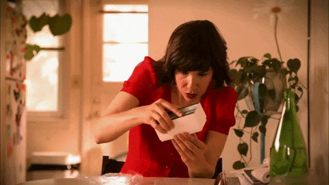 A GIF of a woman opening a new cellphone