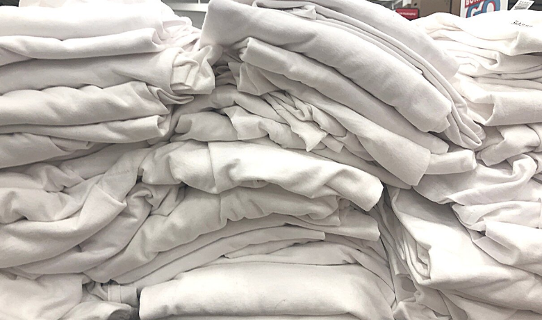 Stack of white t-shirts folded and piled up