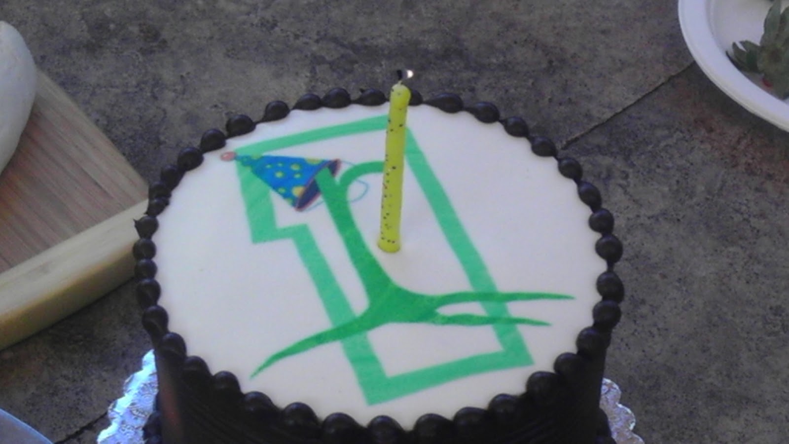 birthday cake with a number 1, a rootid logo and a yellow candle