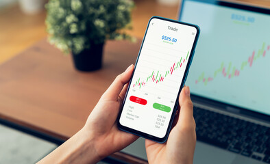 Businessman trader using smartphone with stock market investments and graph on screen to analyze trading data, buy or sell and checking price on mobile application.