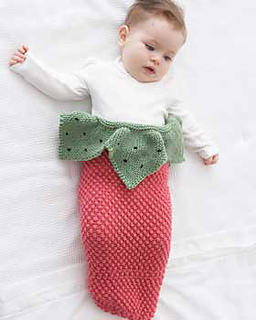 baby in a knitted cocoon that looks like a strawberry