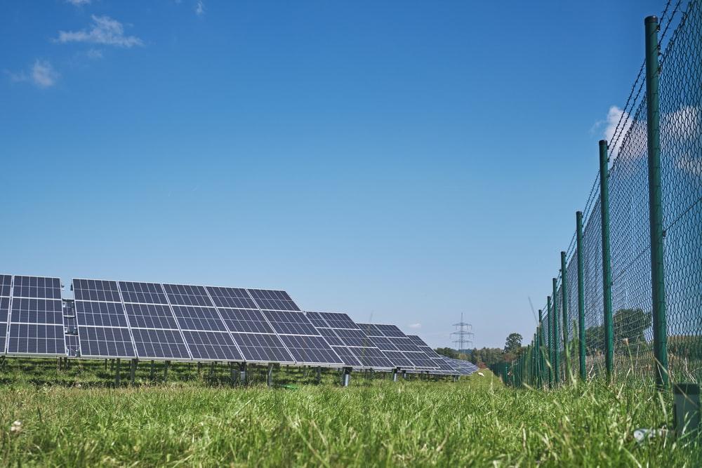 solar panels on green grass field under blue sky during daytime