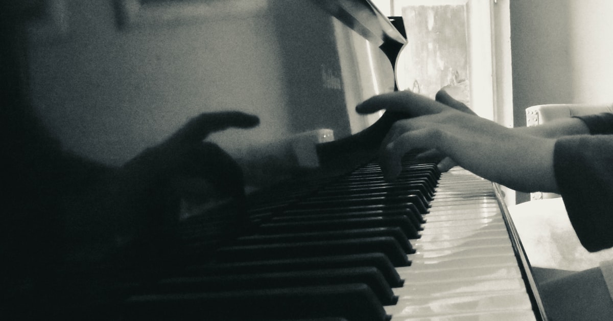 Man's hands touching piano keys