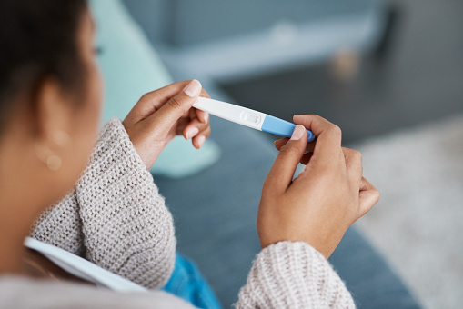 A woman holding a negative pregnancy test while sitting on her couch in her living room. Anxiety treatment in Los Angeles, CA is available here with a skilled anxiety therapist who is willing to help with online therapy in California. Get help for stress, worry, obsessive compulsive disorder and more.  91356 | 91301 | 91302 | 91372
