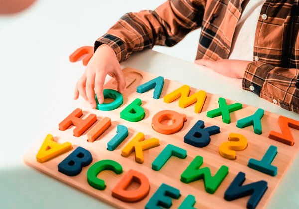 Trẻ học chữ cái qua trò chơi xếp gỗ.