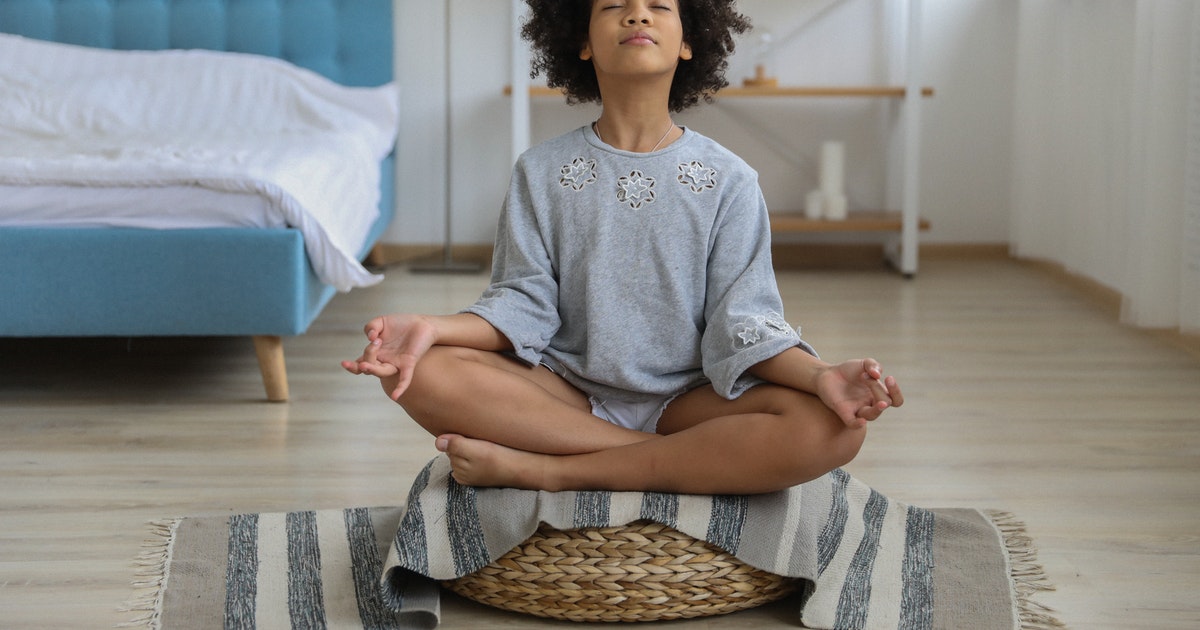 Child meditating quietly on the floor in bedroom