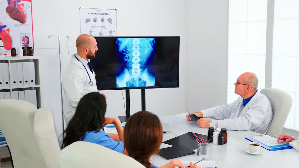 Group of doctors analysing digital radiography during a Radiography Interview, using modern technology to discuss patient diagnoses and treatments.